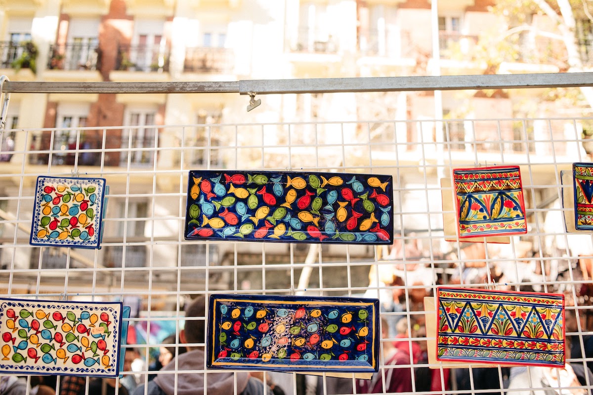 Bandejas de cerámica pintadas a mano de colores brillantes en exhibición en un mercado de pulgas.